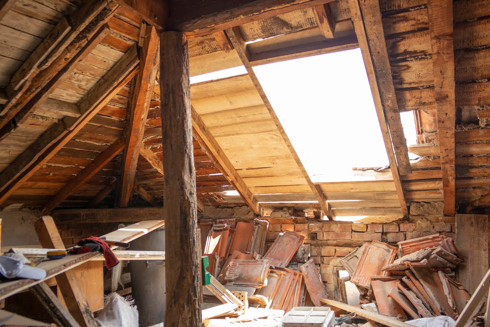 Water leaks in attic and wet roof. Old roof need to be repaired. Rotten boards and old roof tiles. Indoor shot.