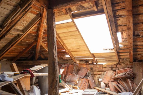 Water leaks in attic and wet roof. Old roof need to be repaired. Rotten boards and old roof tiles. Indoor shot.